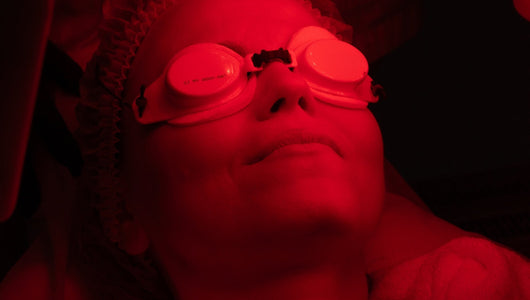 Closeup of woman doing red light therapy and wearing goggles as part of a discussion on whether you need goggles for red light therapy