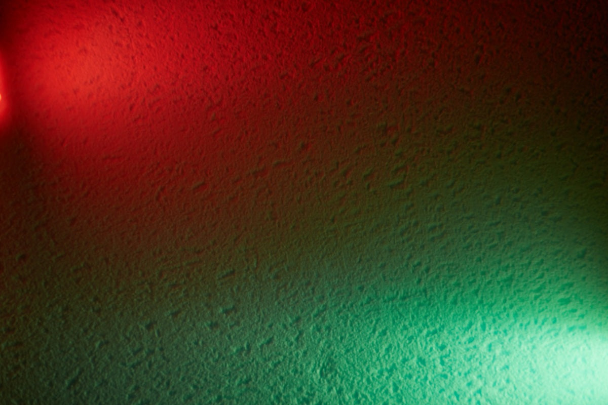 Green light therapy vs red light therapy comparison with abstract red and green LED light background.