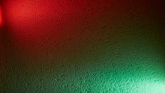 Green light therapy vs red light therapy comparison with abstract red and green LED light background.
