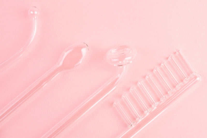 High frequency facial tools on pink background in red light therapy vs high frequency skincare comparison