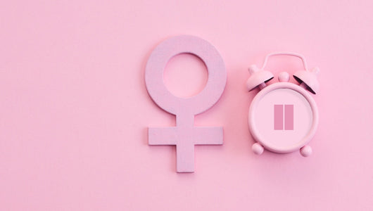 Minimal pink background with female gender symbol and clock illustrating red light therapy and female hormones.