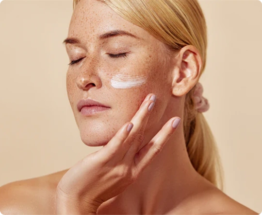 woman applying cream to face